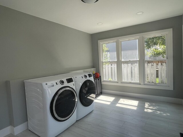 washroom featuring a wealth of natural light, laundry area, independent washer and dryer, and light wood finished floors