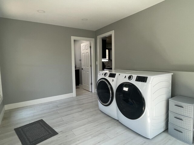 laundry room featuring light hardwood / wood-style floors and separate washer and dryer