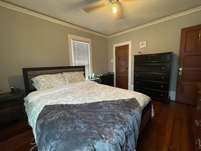 bedroom featuring ceiling fan, dark hardwood / wood-style flooring, and crown molding