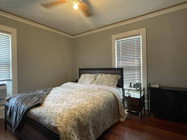 bedroom with ceiling fan, ornamental molding, and dark hardwood / wood-style floors