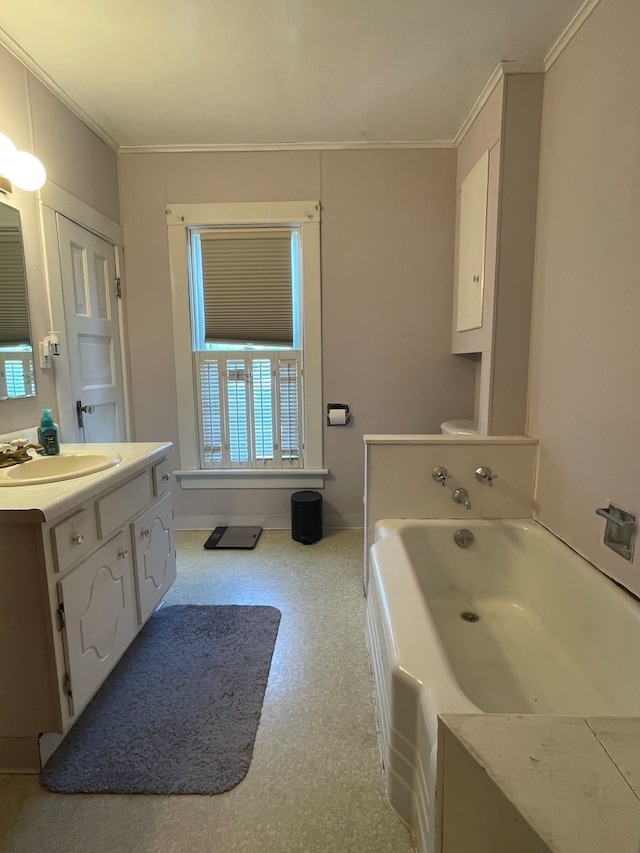 bathroom with toilet, a tub, vanity, and ornamental molding