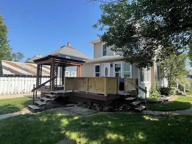 back of house featuring a wooden deck and a lawn