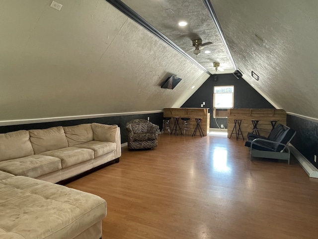 additional living space featuring a textured ceiling, ceiling fan, hardwood / wood-style floors, and lofted ceiling