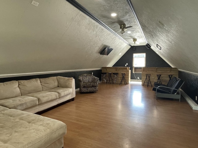 bonus room with ceiling fan, vaulted ceiling, a textured ceiling, and wood finished floors