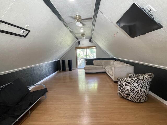 bonus room featuring a textured ceiling, ceiling fan, hardwood / wood-style floors, and vaulted ceiling