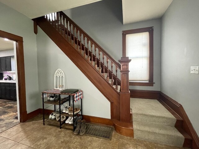 stairway featuring tile patterned flooring