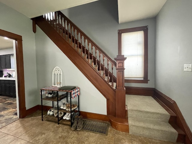 staircase with visible vents and baseboards