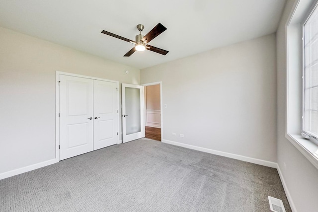 unfurnished bedroom featuring carpet floors, ceiling fan, and a closet