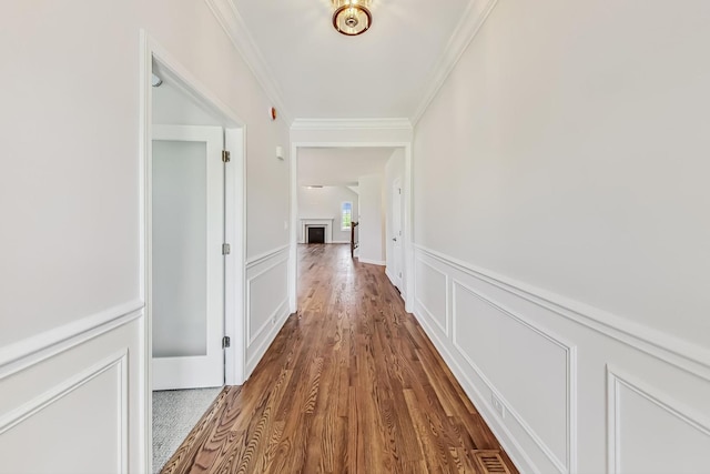 hall with hardwood / wood-style flooring and ornamental molding