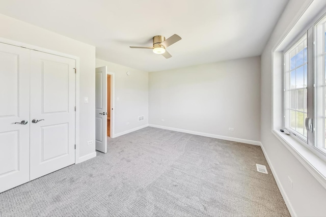 unfurnished bedroom featuring a closet, ceiling fan, and light carpet