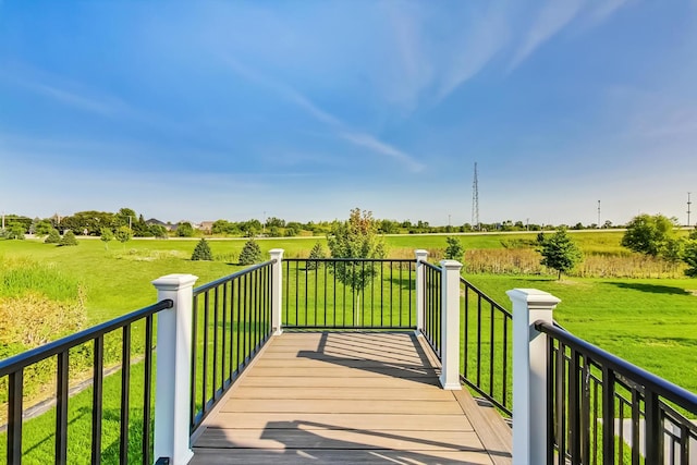 deck featuring a lawn and a rural view