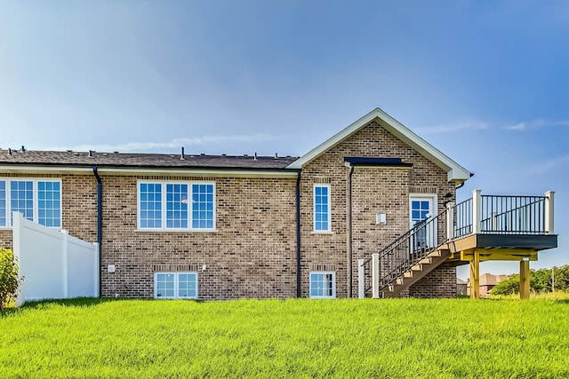 back of property with a lawn and a deck