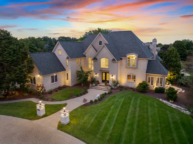 french country home featuring a yard