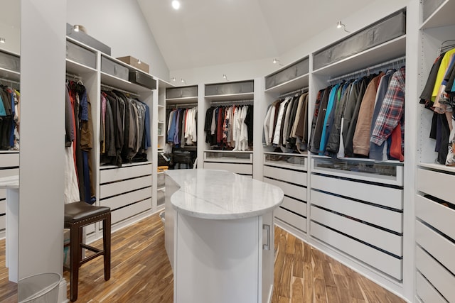 walk in closet with lofted ceiling and light hardwood / wood-style flooring