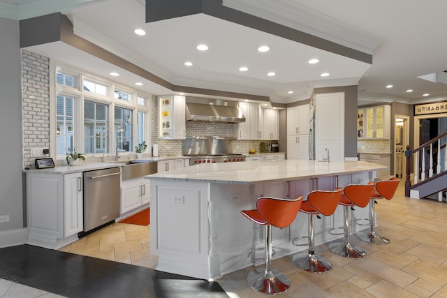 kitchen with dishwasher, light stone counters, white cabinetry, and a kitchen island