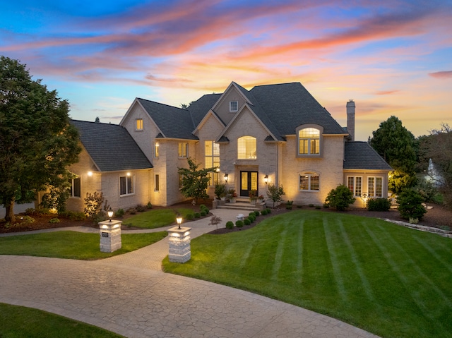 french provincial home featuring a yard