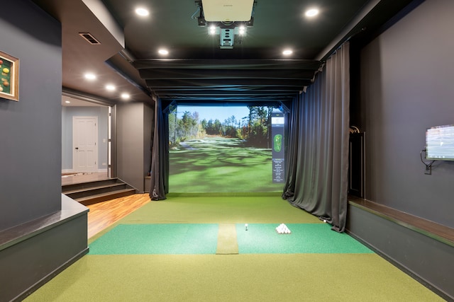 playroom with hardwood / wood-style floors and golf simulator