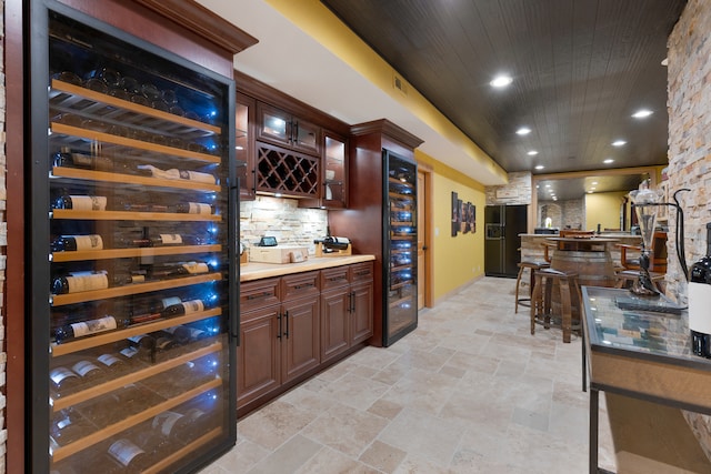 wine room with bar area, beverage cooler, and wood ceiling