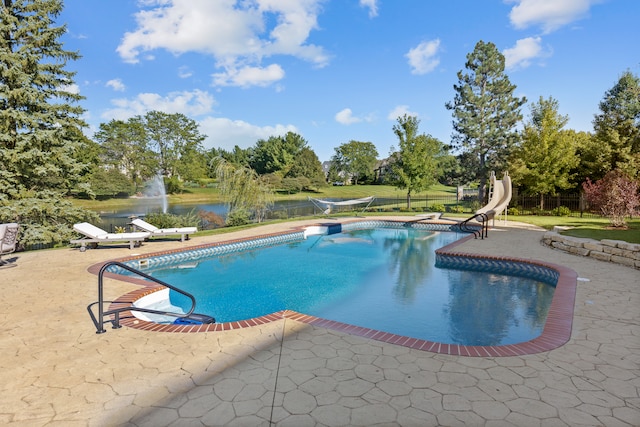 view of pool featuring a water view, a water slide, and a patio