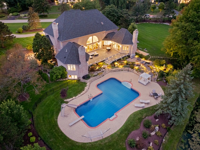 view of swimming pool with a diving board, a yard, and a patio