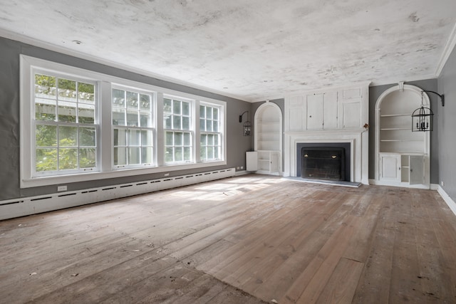 unfurnished living room featuring hardwood / wood-style floors, baseboard heating, ornamental molding, and a healthy amount of sunlight