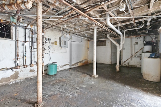 basement featuring electric panel and water heater