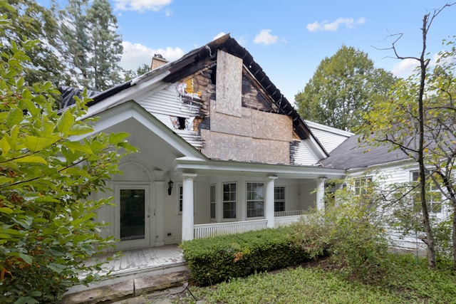 rear view of house featuring a porch