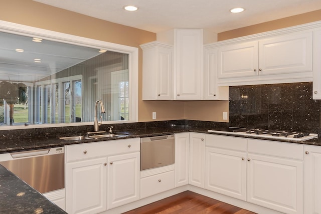 kitchen with white gas stovetop, sink, stainless steel dishwasher, dark hardwood / wood-style floors, and white cabinetry