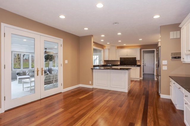 kitchen with a healthy amount of sunlight, dark hardwood / wood-style flooring, white cabinetry, and french doors