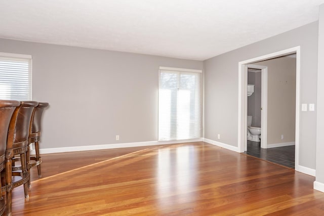 living area with baseboards and wood finished floors