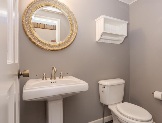 bathroom with a sink, baseboards, and toilet