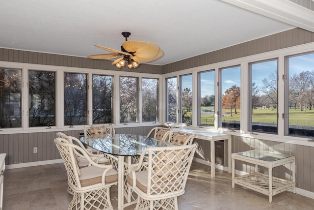 sunroom / solarium featuring plenty of natural light and a ceiling fan