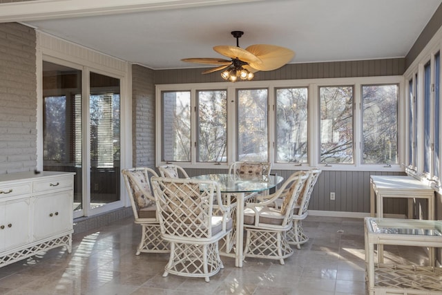 unfurnished sunroom featuring ceiling fan