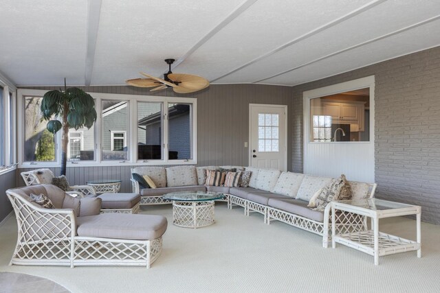 exterior space featuring ceiling fan, a textured ceiling, and brick wall