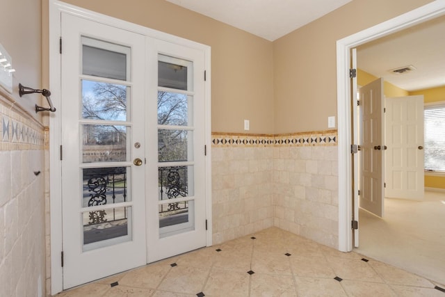 entryway featuring tile patterned flooring and tile walls