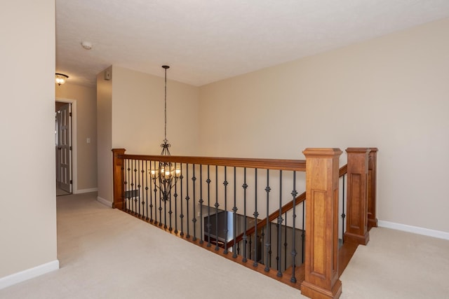 hallway with carpet flooring and an inviting chandelier