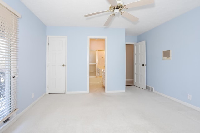 unfurnished bedroom featuring visible vents, ensuite bath, carpet, baseboards, and ceiling fan