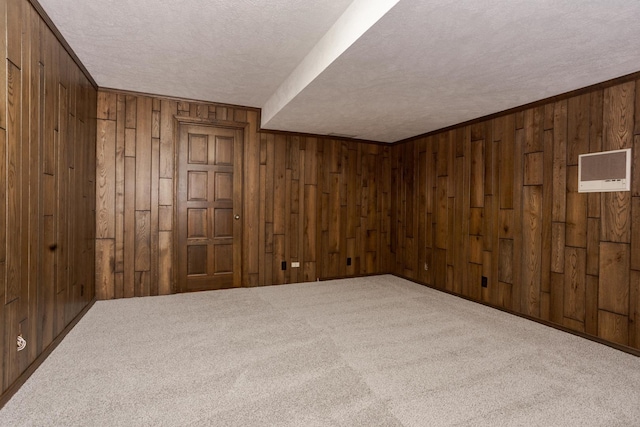 finished basement featuring carpet, crown molding, wooden walls, and a textured ceiling