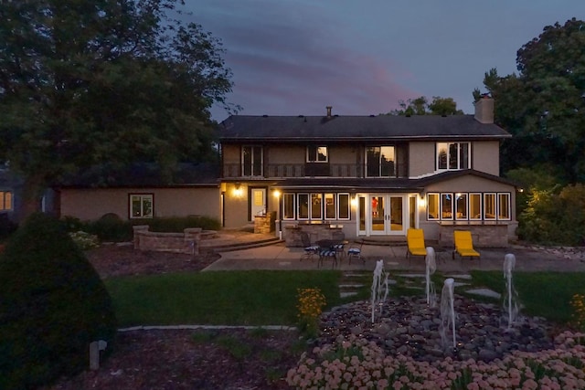 rear view of property featuring french doors, a chimney, and a patio