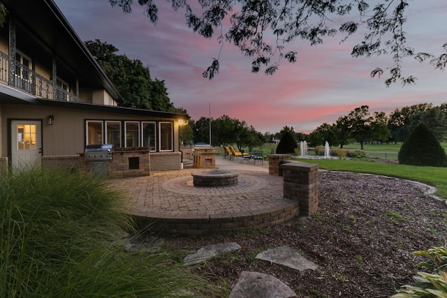 yard at dusk featuring a patio area and an outdoor kitchen