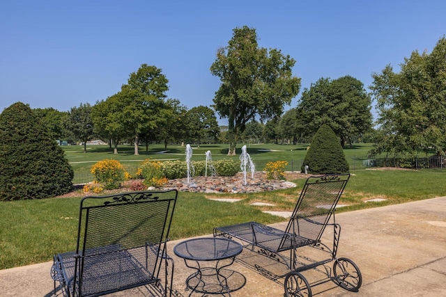 view of property's community with a lawn and a patio