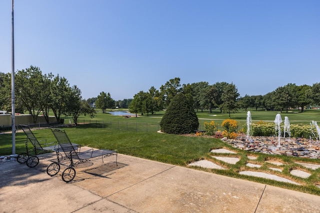 surrounding community featuring a patio, a water view, a yard, and fence