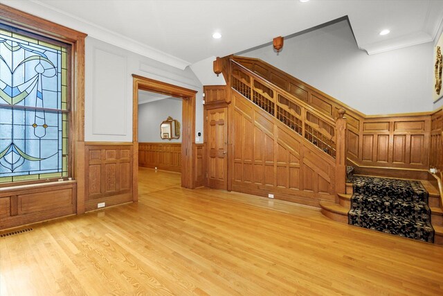 foyer featuring light wood-type flooring and crown molding