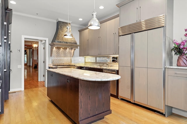 kitchen with custom range hood, backsplash, light wood-type flooring, paneled built in refrigerator, and a kitchen island