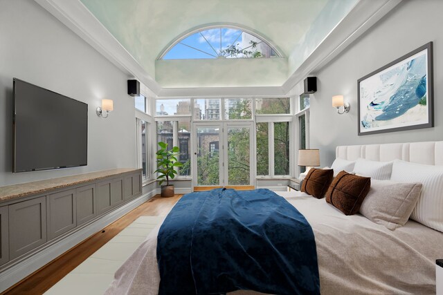 bedroom featuring light hardwood / wood-style floors and a high ceiling