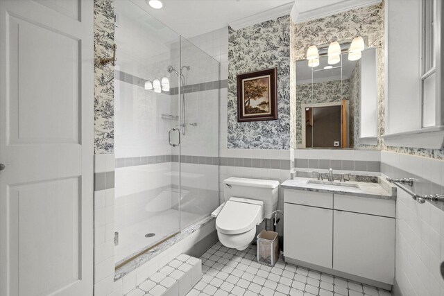 bathroom with toilet, tile patterned flooring, an enclosed shower, vanity, and tile walls