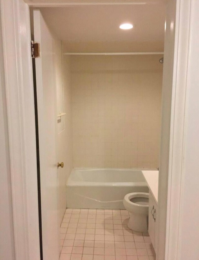 full bathroom featuring tile patterned flooring, vanity, tiled shower / bath combo, and toilet