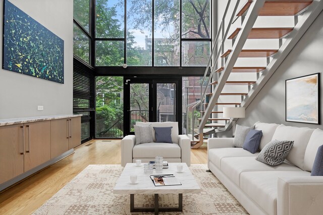 living room with a high ceiling and light wood-type flooring