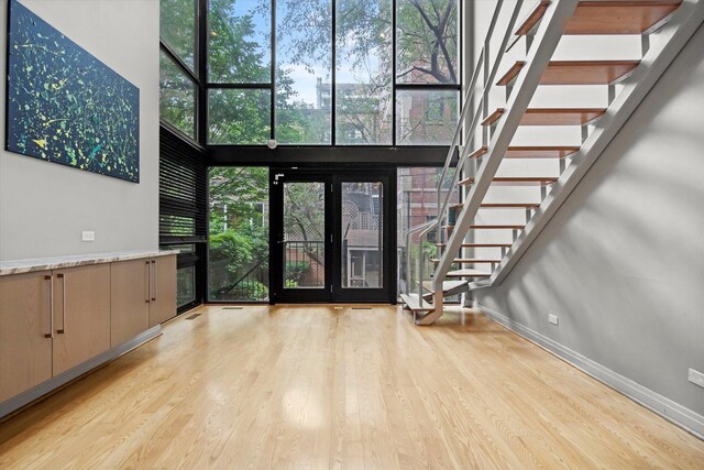 entrance foyer with a healthy amount of sunlight, french doors, and light wood-type flooring