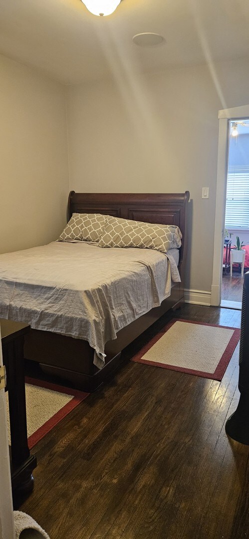 bedroom with dark wood-type flooring and vaulted ceiling